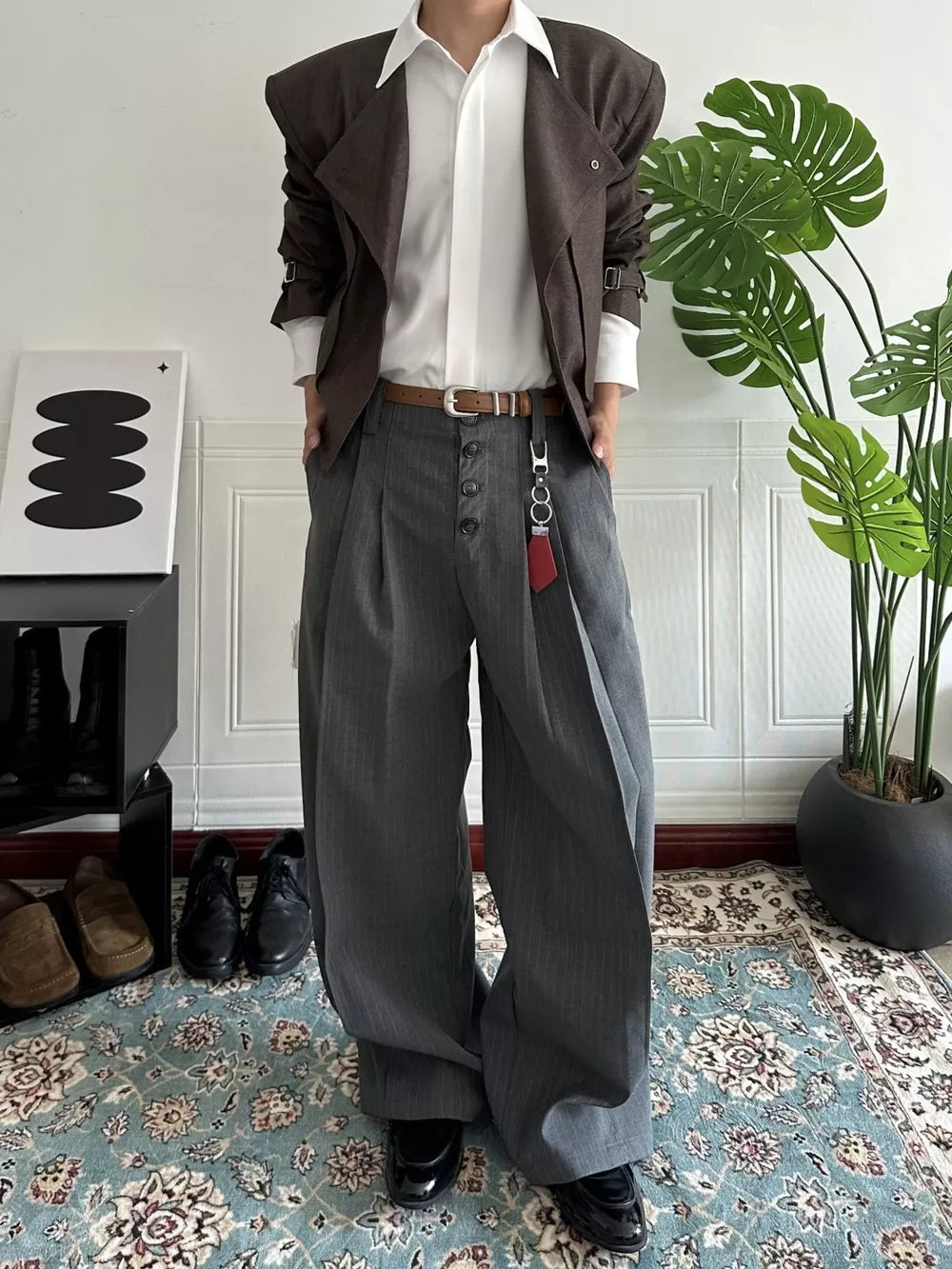 Men's gray pinstripe high-waisted wide-leg pants with button fly and pleated front.