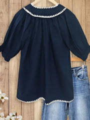 Navy polyester blouse with scalloped white trim collar and hem, tie neck, and puff sleeves.