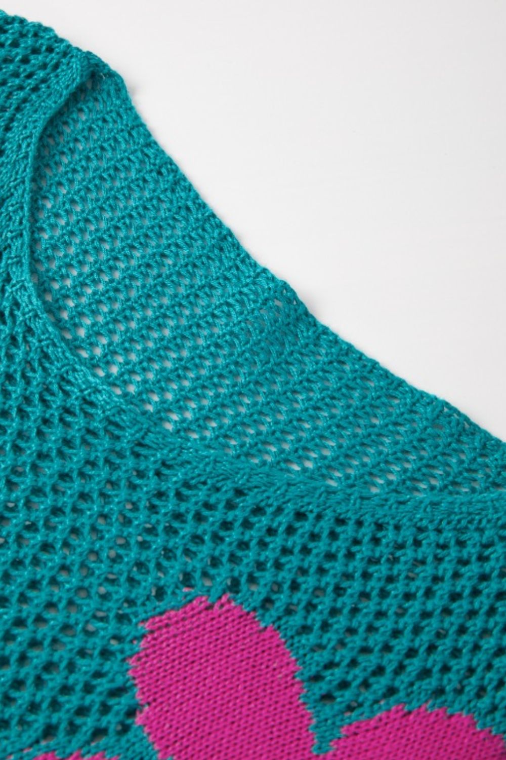 Openwork floral intarsia sweater in teal with pink floral detail, acrylic knit.