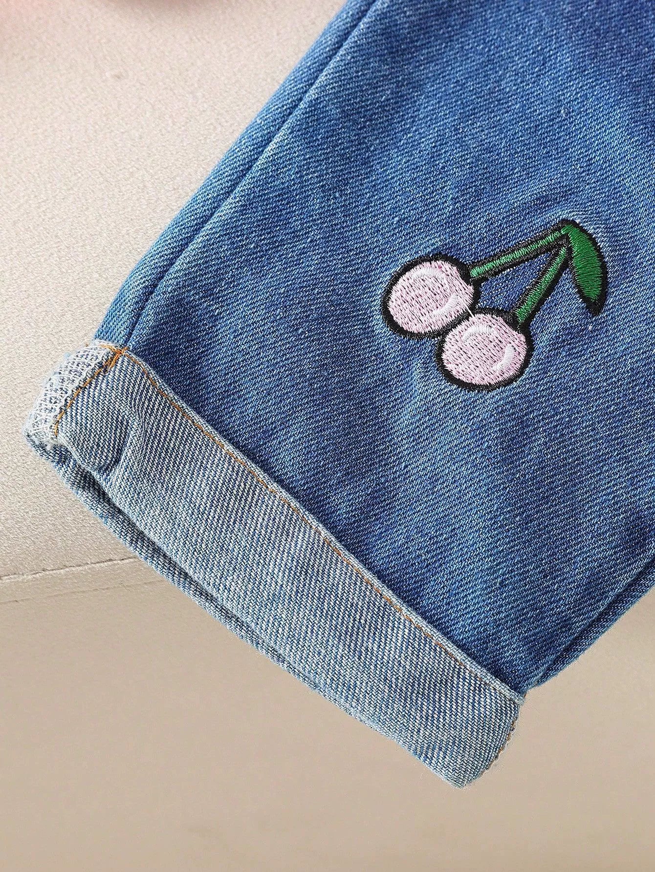 Baby denim set with embroidered cherries and cuffed hem.