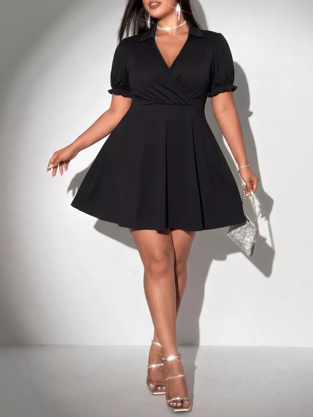 Black plus-size mini dress with surplice neckline, puff sleeves, and flared skirt.