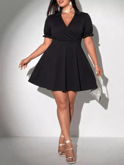 Black plus-size mini dress with surplice neckline, puff sleeves, and flared skirt.