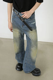 Faded patchwork denim palazzo trousers in medium wash with distressed details and wide legs.