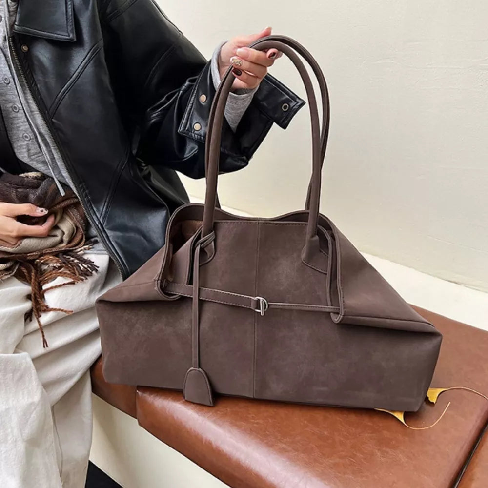 Brown suede tote handbag with decorative strap detail and double handles.