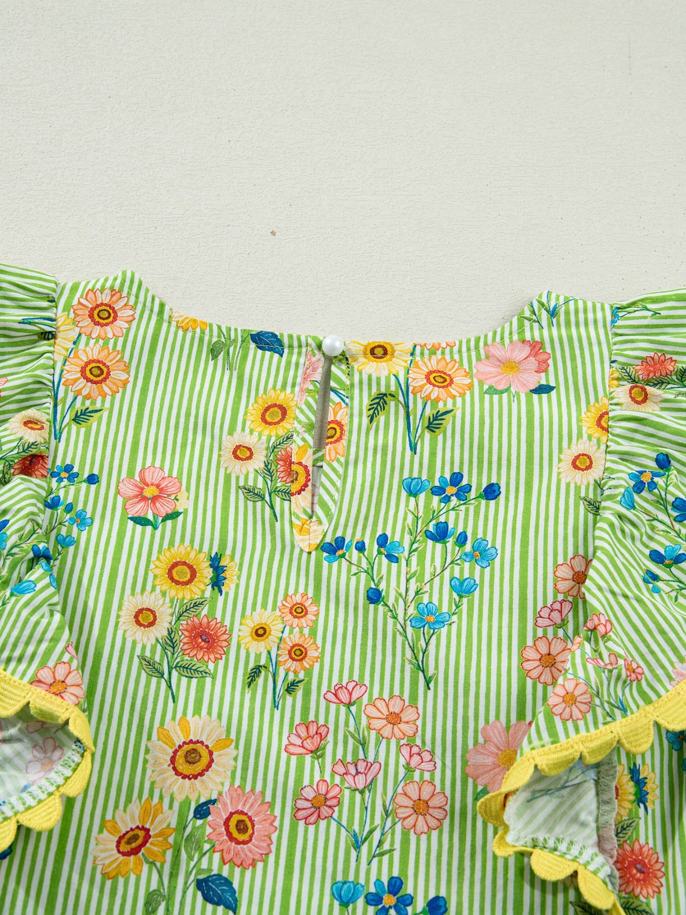 Floral printed cotton blouse with green stripes, ruffle sleeves, and yellow trim.