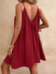 Red spaghetti strap gauze dress with tie back detail and textured fabric.
