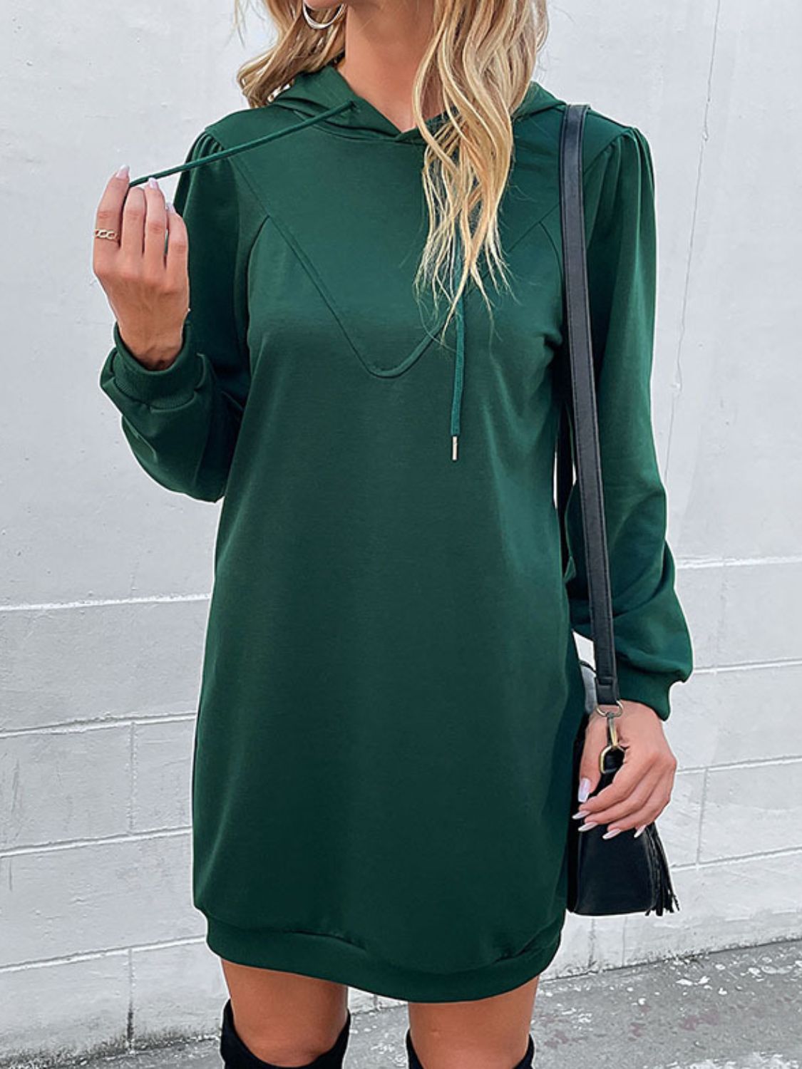 Green hooded mini dress with sculpted shoulders and drawstring detail.