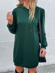Green hooded mini dress with sculpted shoulders and drawstring detail.