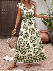 Botanical print V-neck maxi dress in cream with green botanical pattern, cap sleeves, and tiered skirt.