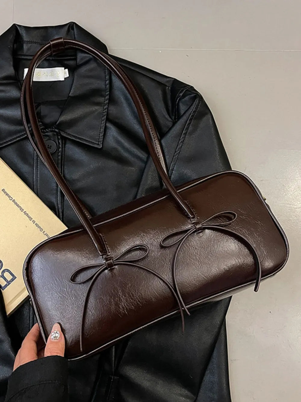 Brown patent leather shoulder bag with bow details