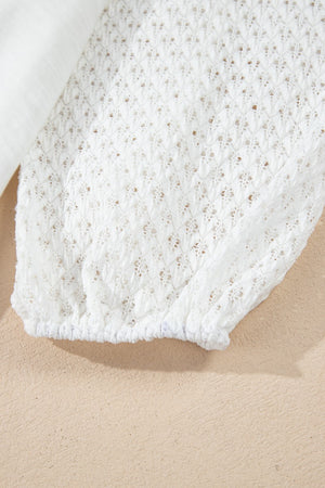 White lace-inset dolman sleeve blouse with textured detail and elastic cuff.