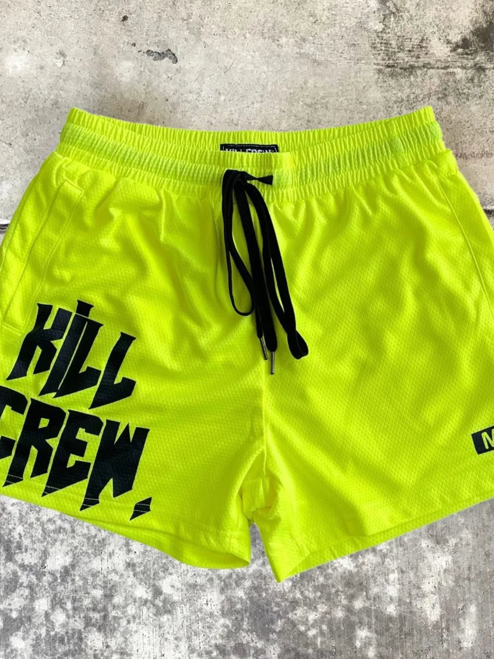 Neon green graphic training shorts with black drawstring and Kill Crew logo.