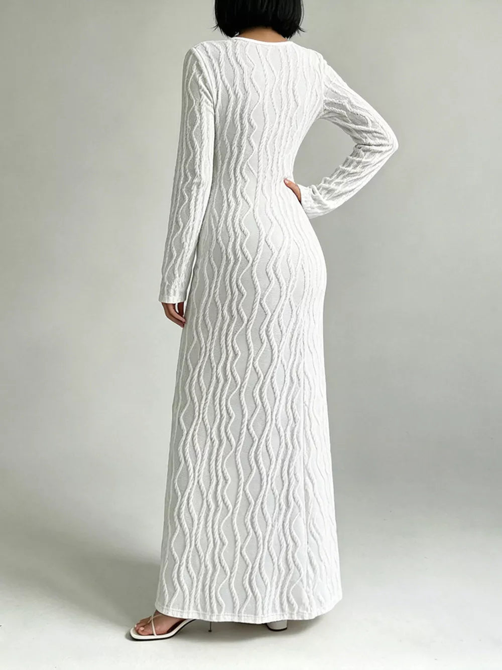 White textured long sleeve maxi dress with cutout detail and a pullover closure.