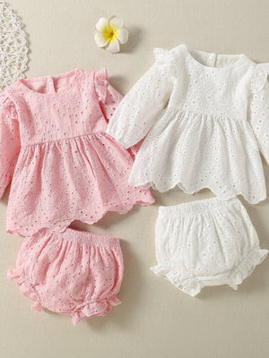 Embroidered lace baby top and shorts set in white and pink with ruffled details.