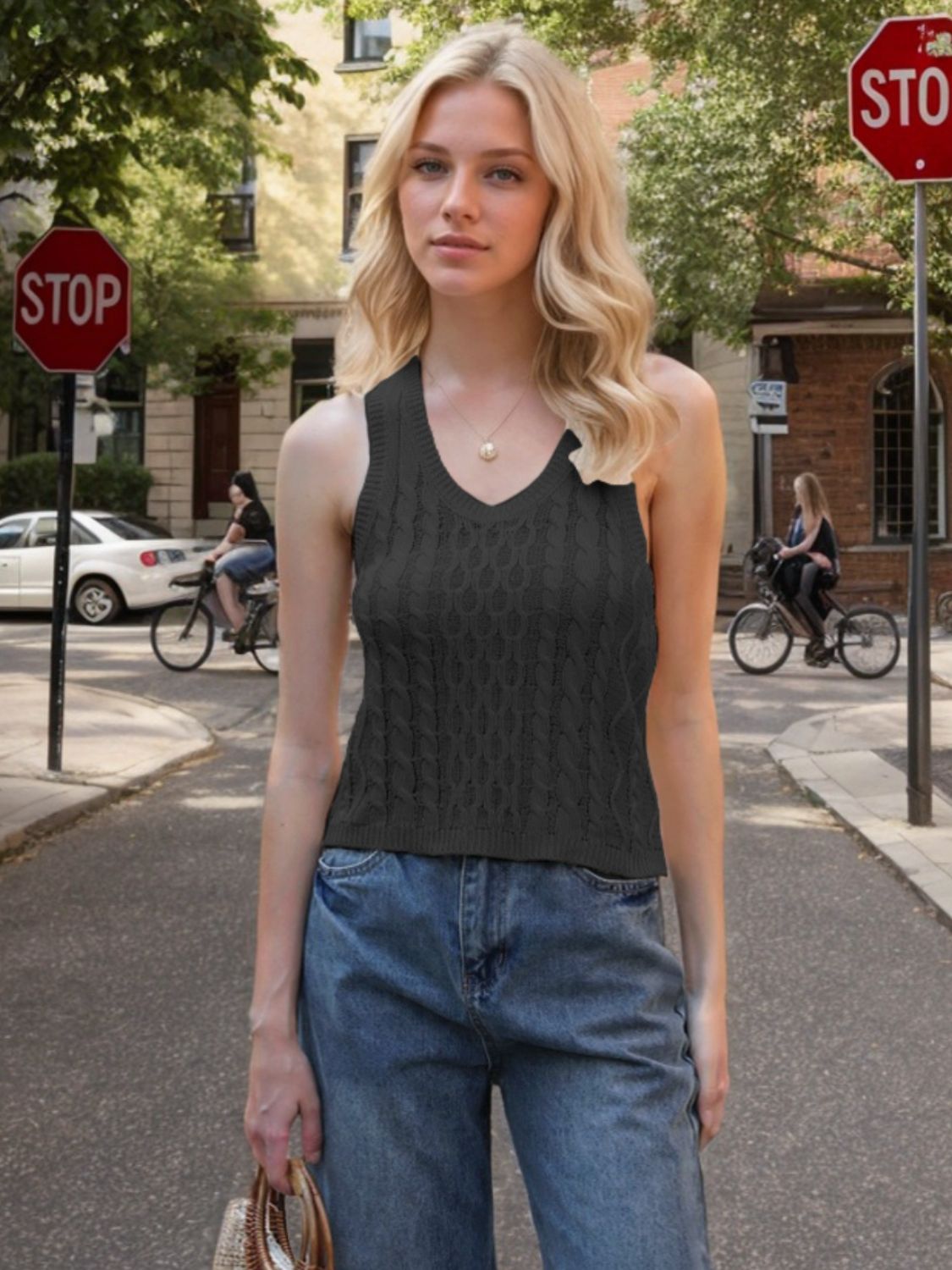 Black cable knit tank top with V-neck and sleeveless design.