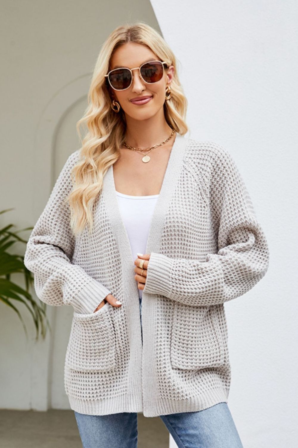 Light gray waffle knit cardigan with patch pockets and ribbed cuffs.