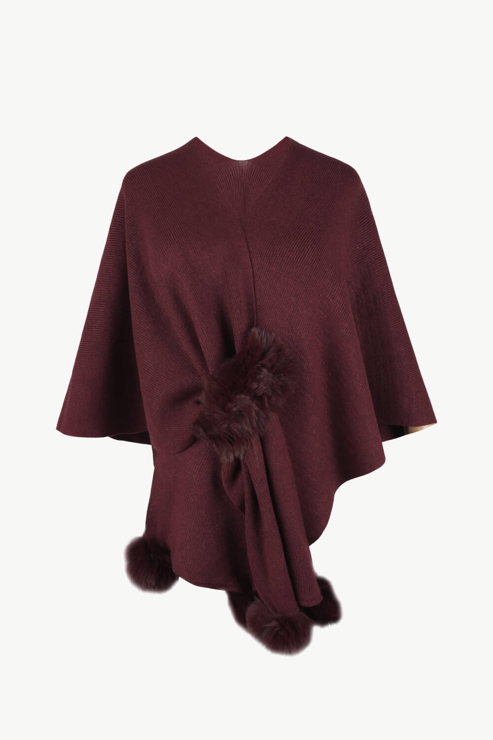 Wine knit cape with fur trim detail and pom poms.