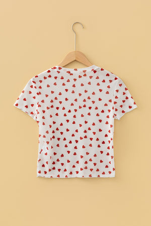White sheer t-shirt with all-over red heart print, short sleeves, and a cropped fit.