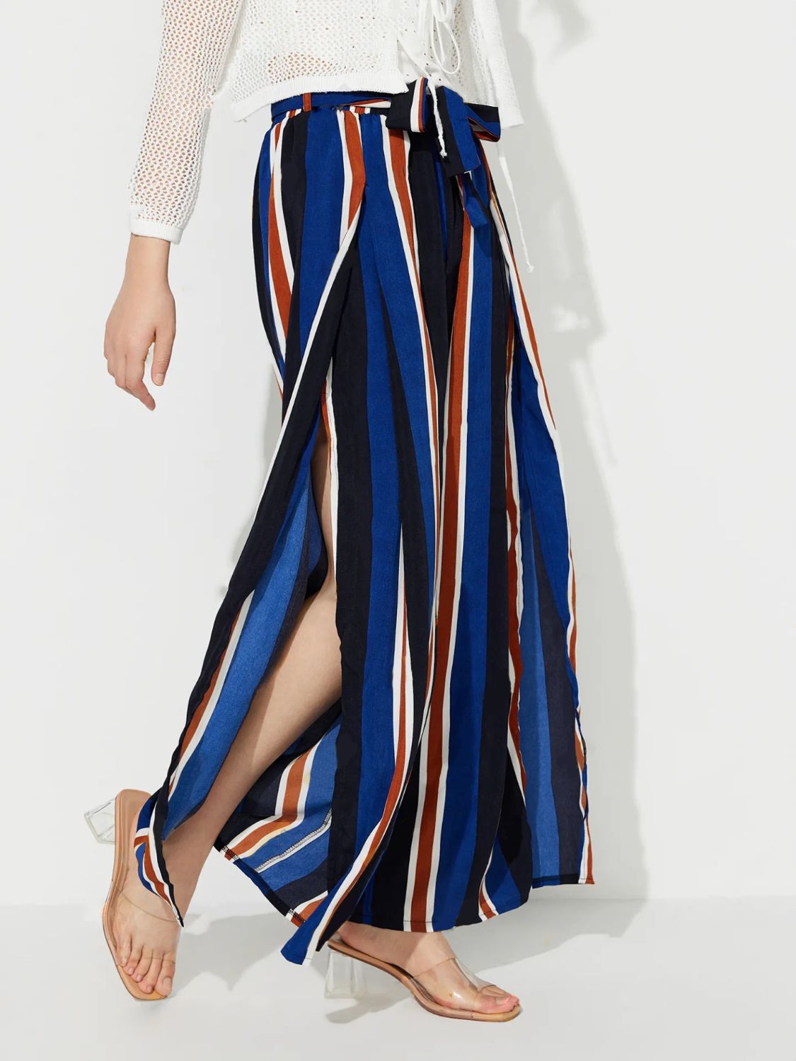 Striped palazzo trousers with side slits and a tie waist in blue, white, and rust stripes.
