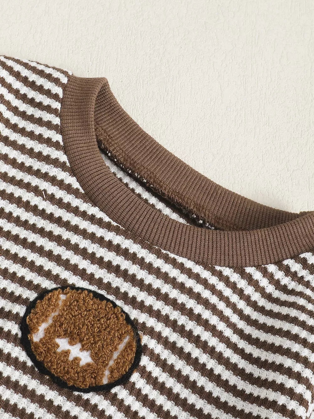 Baby set with brown and white stripes and a football applique.