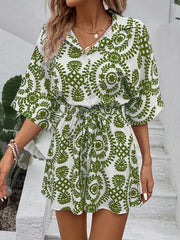 Green printed tie-waist romper with button front and short sleeves.