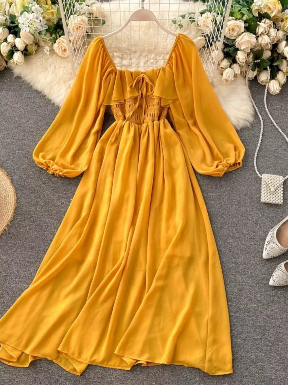Yellow maternity dress with square neck, ruffled detail, smocked bodice, balloon sleeves, and A-line skirt.