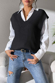 Black textured knit v-neck sleeveless top over a white button-down shirt.