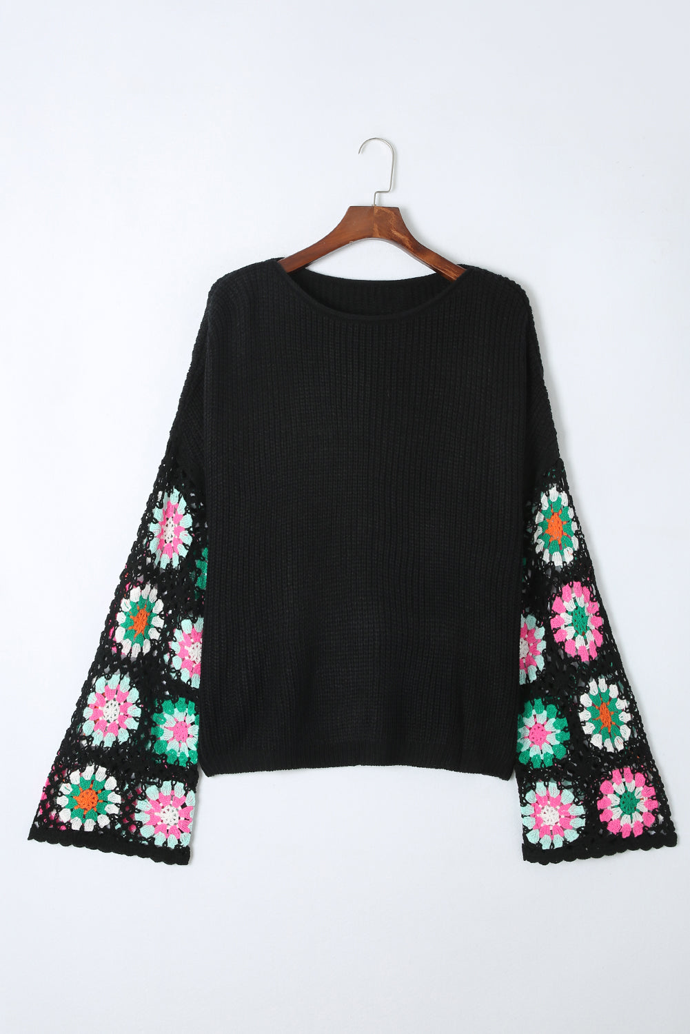 Black knit pullover sweater with crochet granny square bell sleeves in colorful floral patterns.