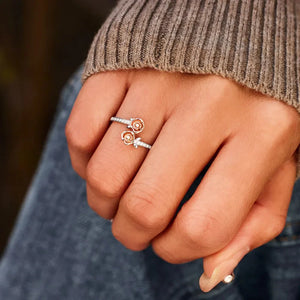 Silver bypass ring with rosebud details and pavé accents on a hand.