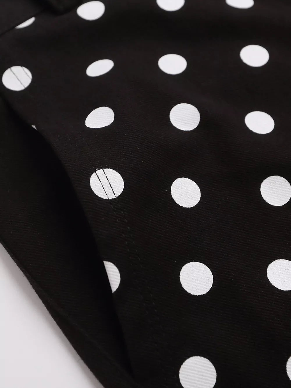Black polka dot cargo shorts with a visible pocket detail.