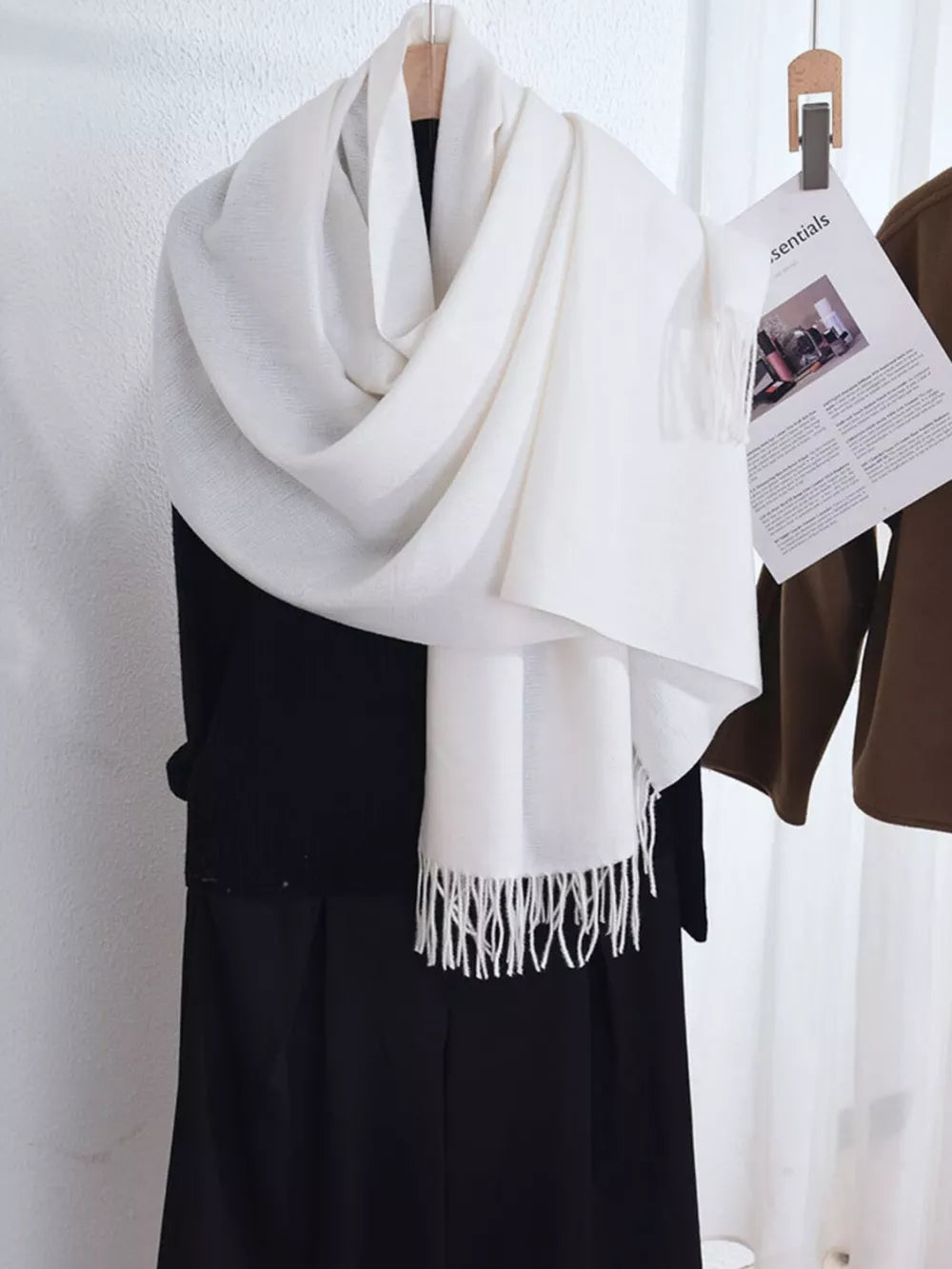 Ivory scarf with fringe detail, draped over a black garment.