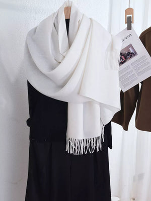 Ivory scarf with fringe detail, draped over a black garment.