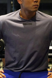 Dark gray oversized t-shirt with a small black logo on the chest.