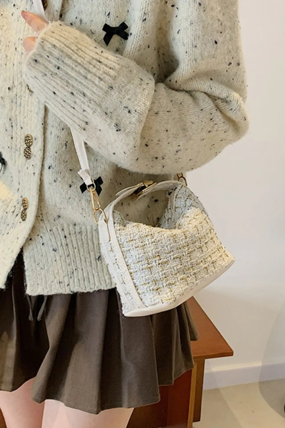 Tweed box bag in ivory with gold threads and detachable strap, styled with a speckled cardigan.