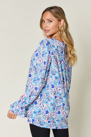 Painterly print blouse in sky blue with gathered sleeves and a keyhole back detail.