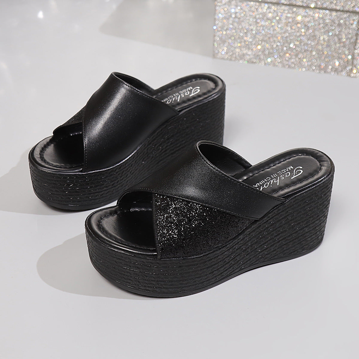 Black open-toe wedge sandals with glitter detail and cross-over straps.