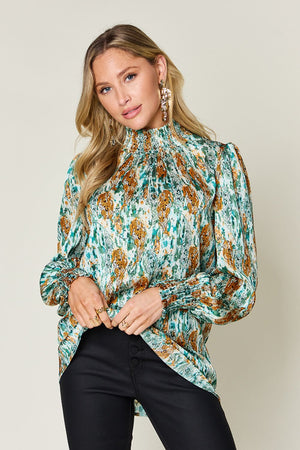 High neck abstract print blouse in green with smocked cuffs and collar