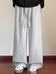 Men's gray drawstring wide-leg sweatpants with pockets and a relaxed fit.