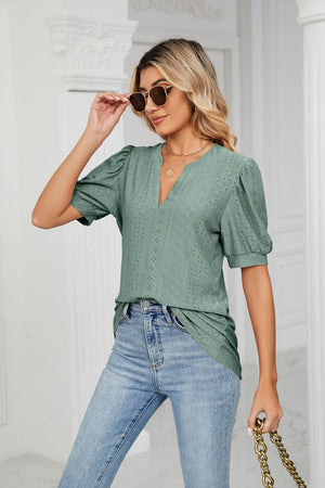 Sage green perforated puff sleeve blouse with keyhole neckline.