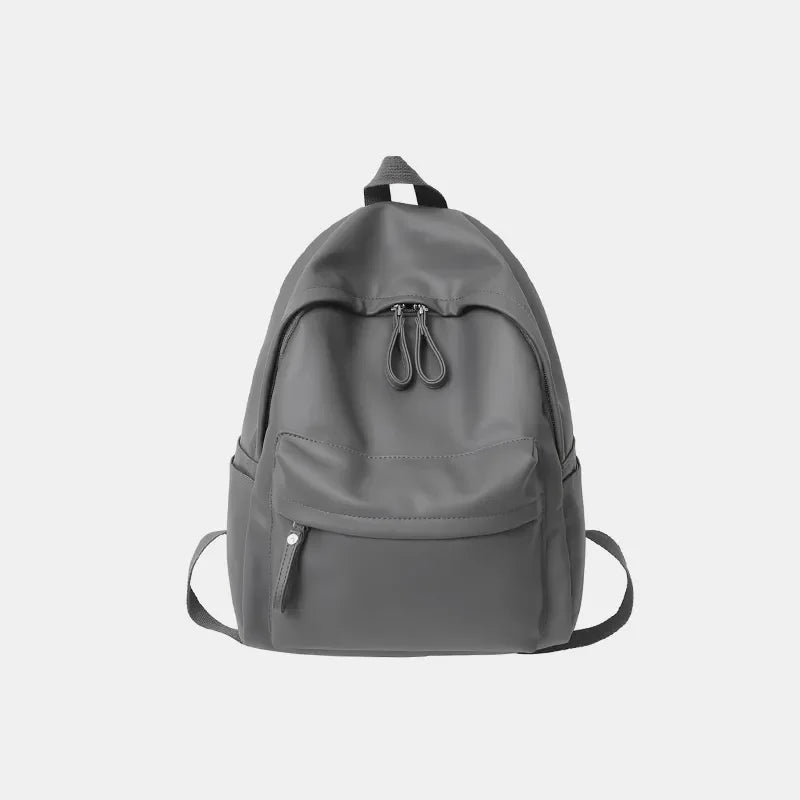 Minimalist dark gray leather backpack with front pocket and double zipper closure.