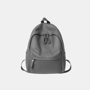 Minimalist dark gray leather backpack with front pocket and double zipper closure.