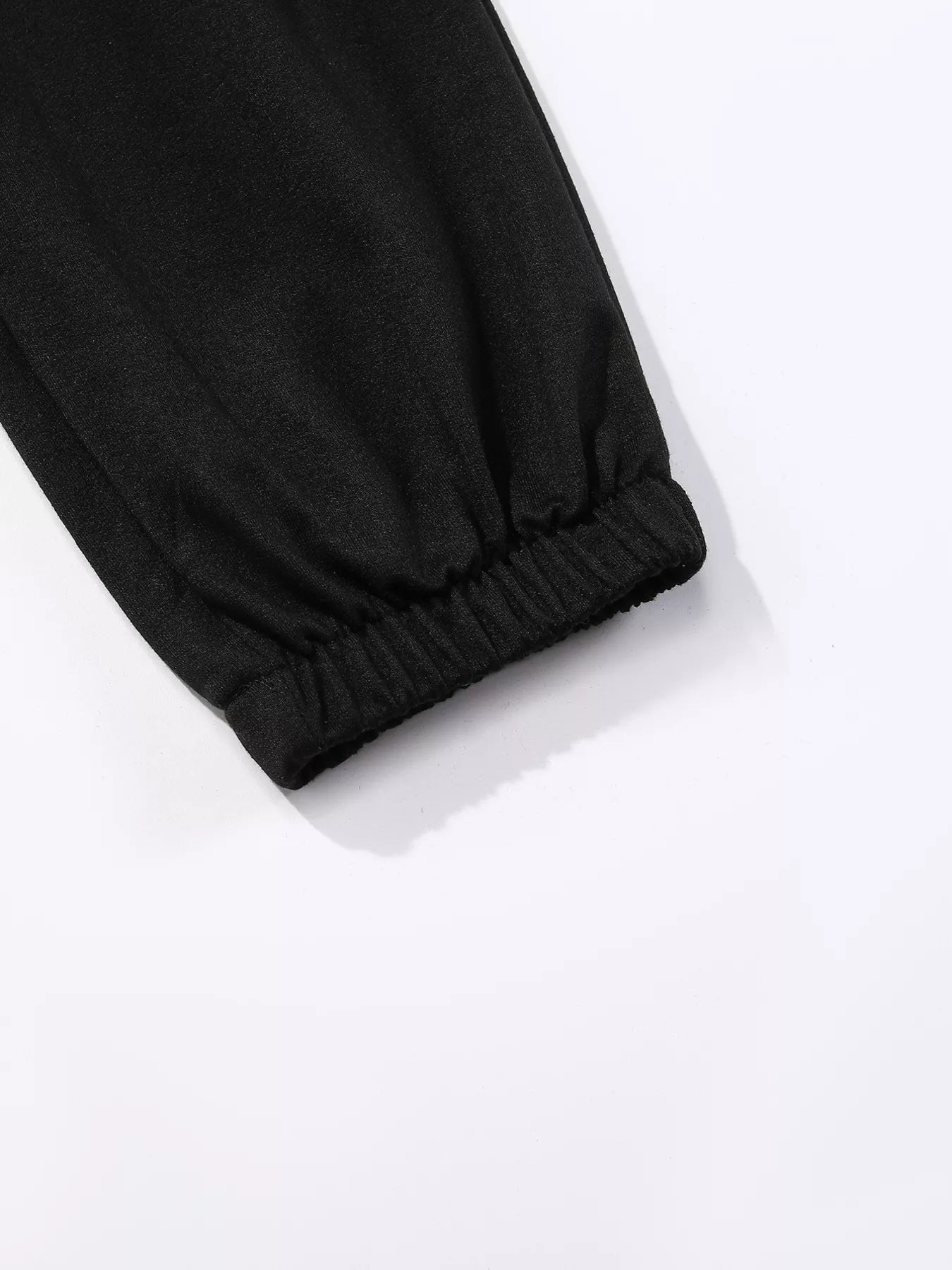 Black sweatpants with elasticated cuffs and subtle butterfly embellishment detail.