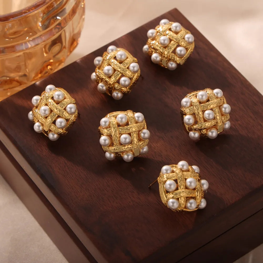 Gold woven pearl grid earrings with a textured finish.