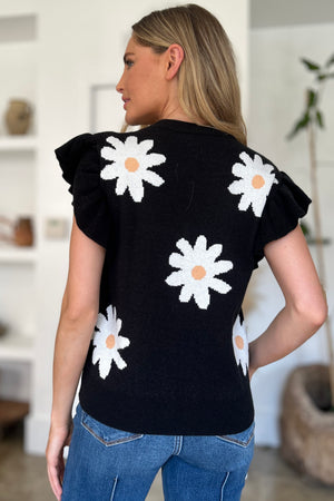 Black knit top with daisy pattern and ruffle sleeves