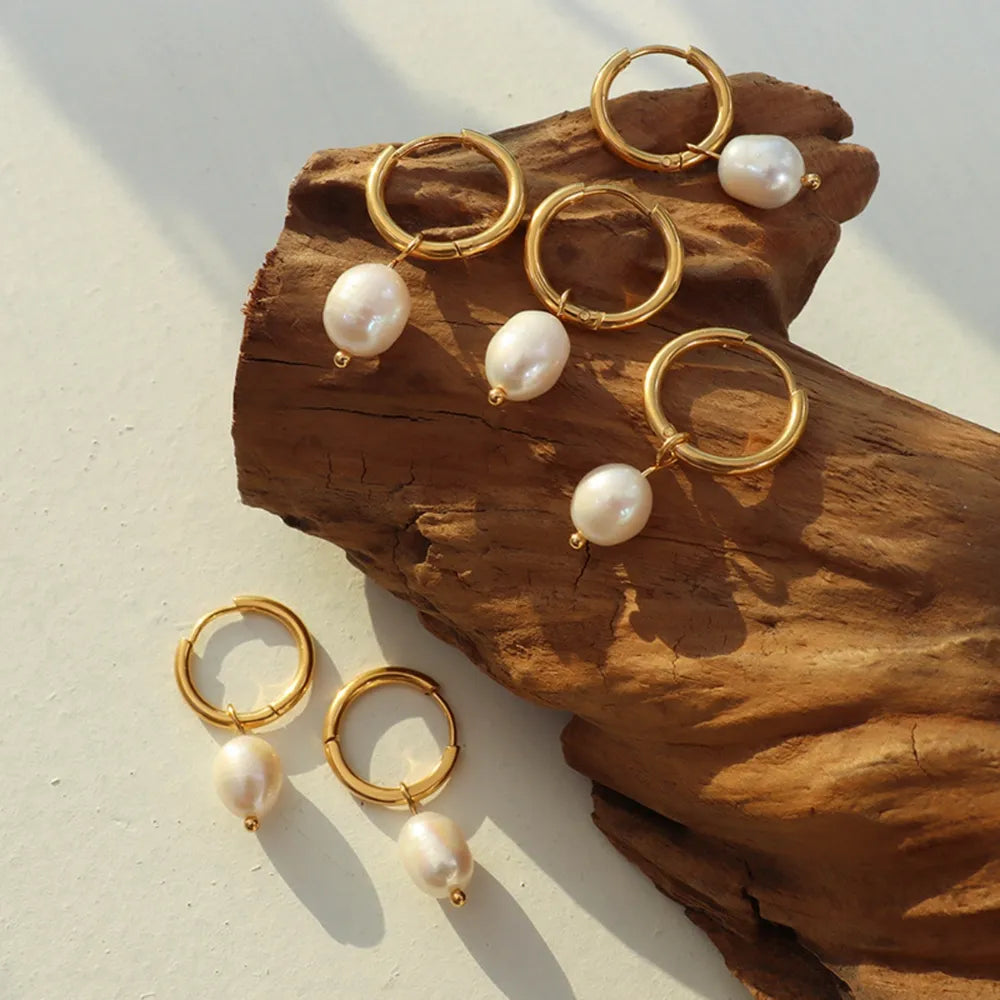 Gold hoop earrings with lustrous pearl drops, chic and elegant for women.