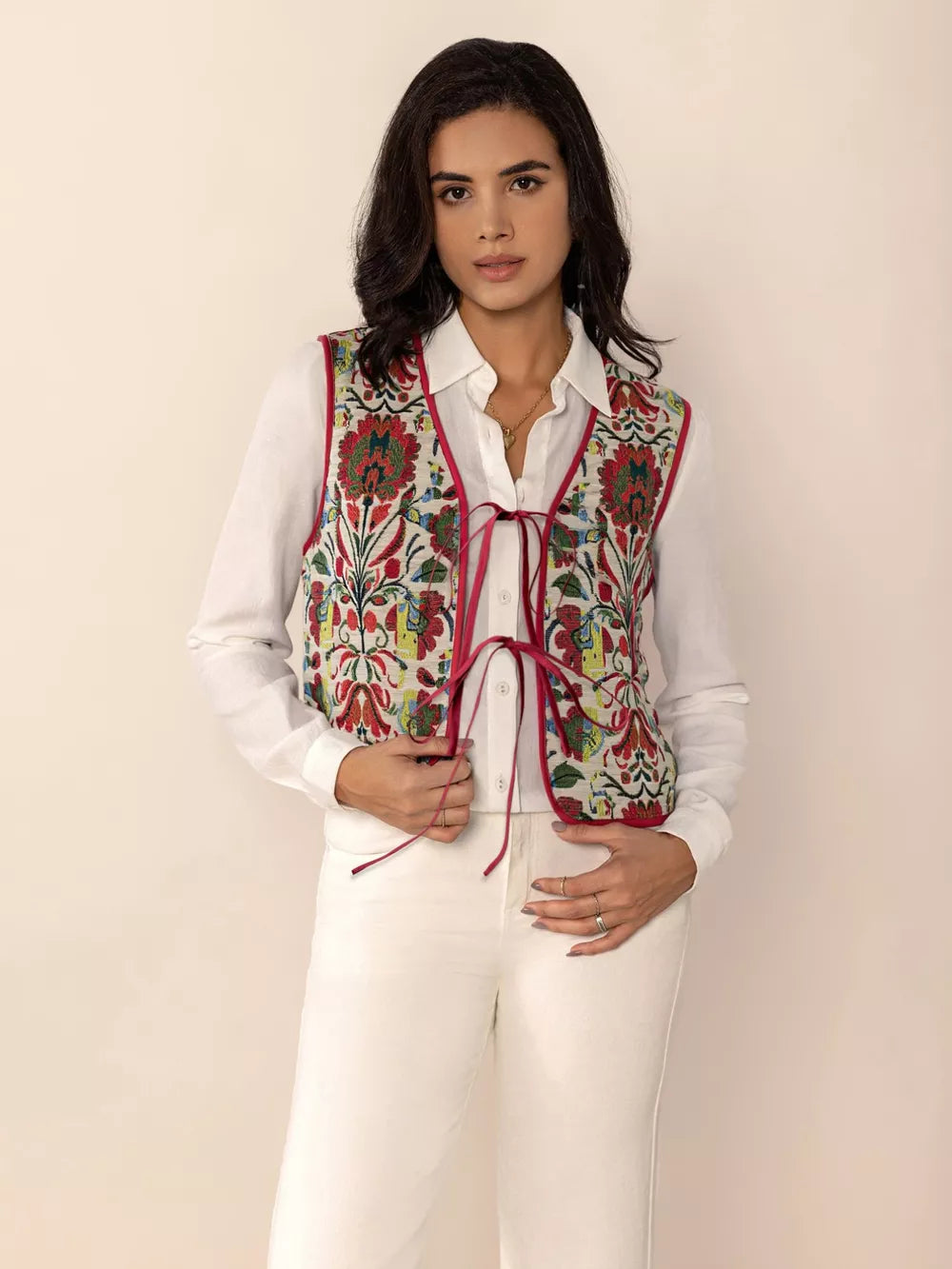 Embroidered tie-front cropped vest coat in deep red with floral pattern, worn over a white shirt.