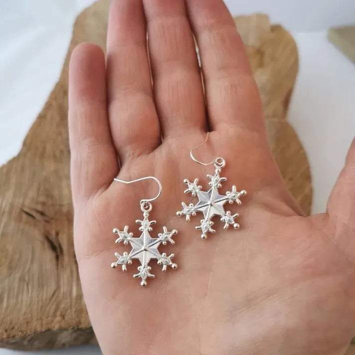Silver snowflake drop earrings with delicate details.