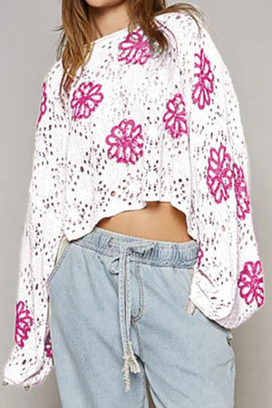 White eyelet knit pullover with floral embroidery and bell sleeves.