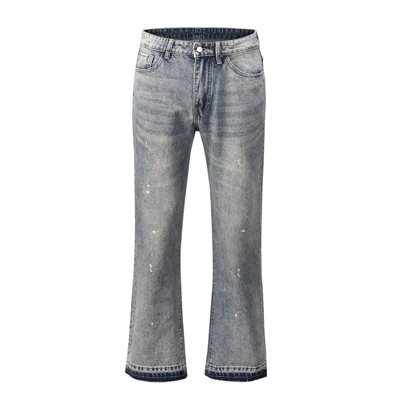 Distressed wash bootcut jeans with raw hem in medium blue denim, featuring paint splatters and a flared leg.