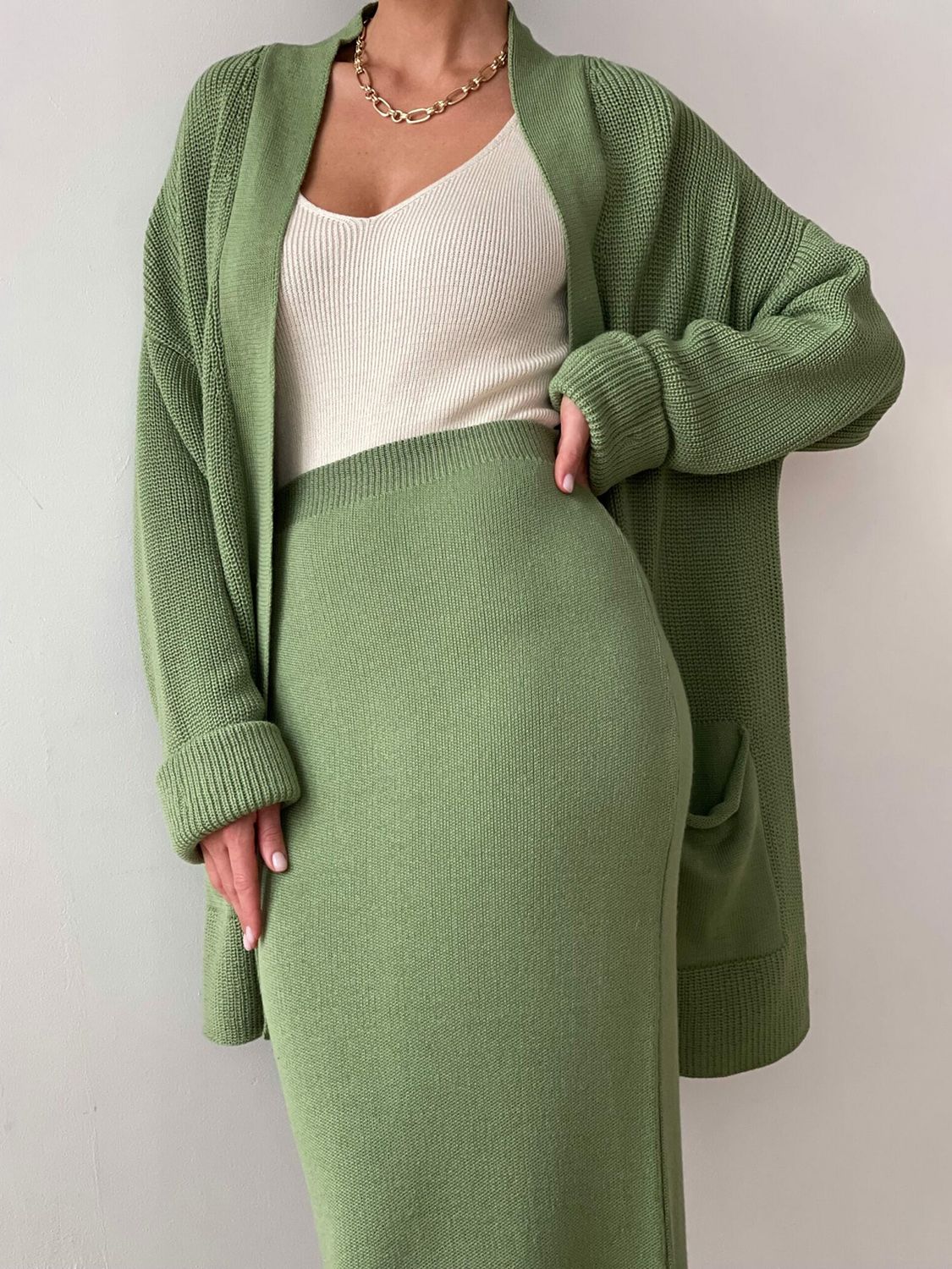 Ribbed knit co-ord set in Gum Leaf green, featuring a long cardigan with pockets and a midi skirt.